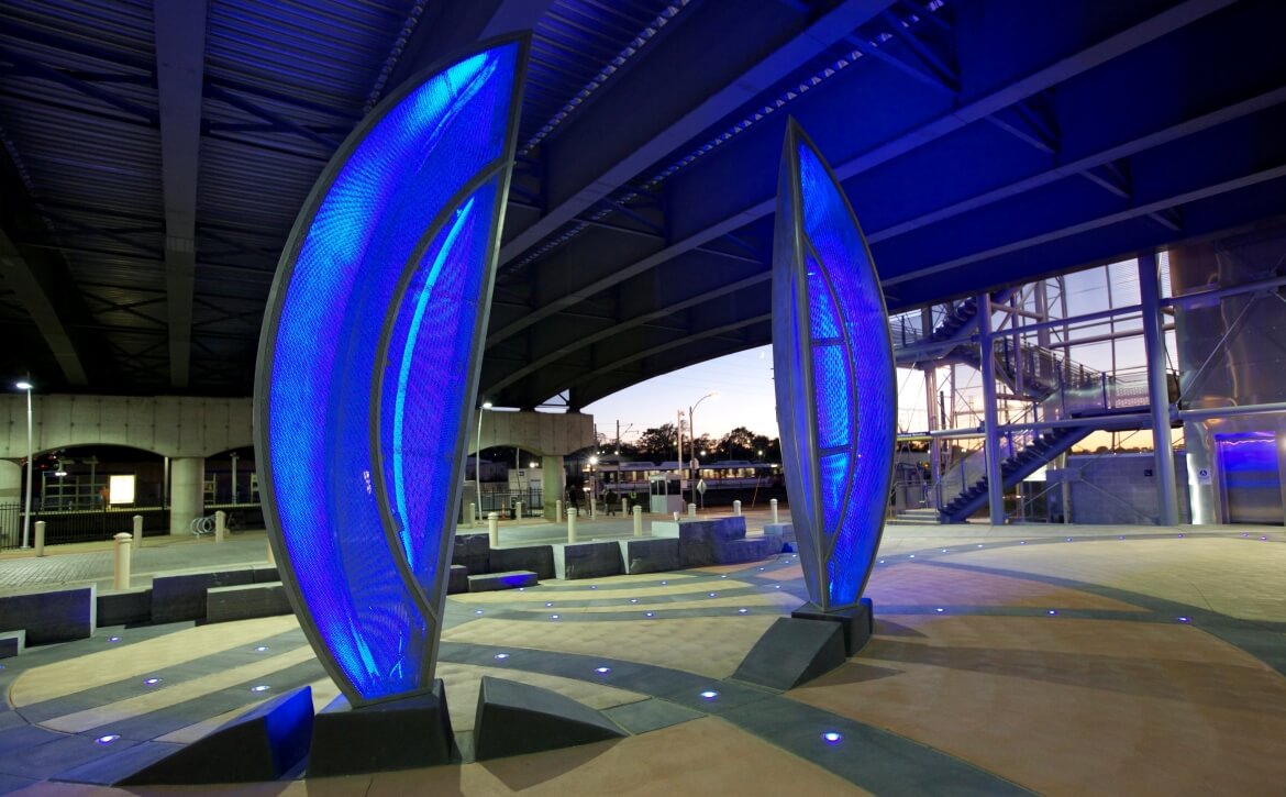 Garden under the Bridge is a public art installation by Barbara Grygutis located at the Grand MetroLink Station. The central seed pod sculptures create a gateway to the station an illuminate the surrounding plaza of embedded lights and pigmented concrete.